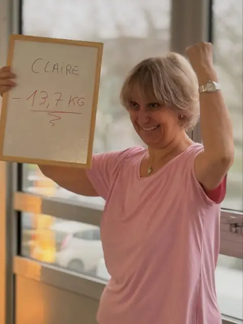 Souriante, une membre montre au club ce que dit son ardoise de bilan